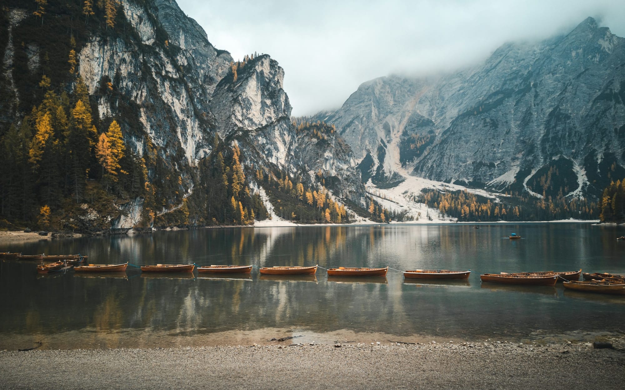 Mountains next to a lake with canoes
